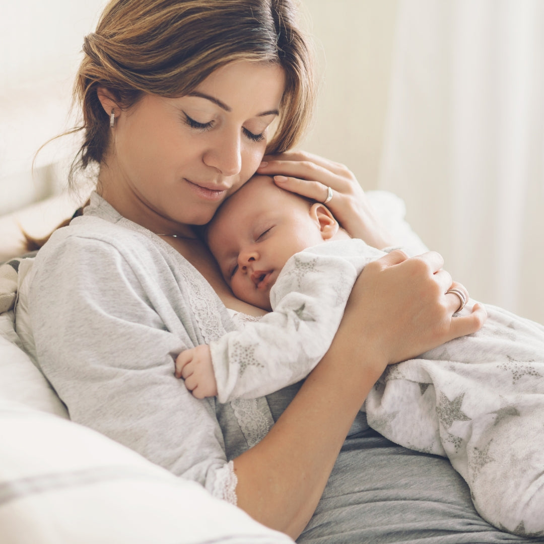 New mum gently cuddling her newborn baby during the early days of motherhood