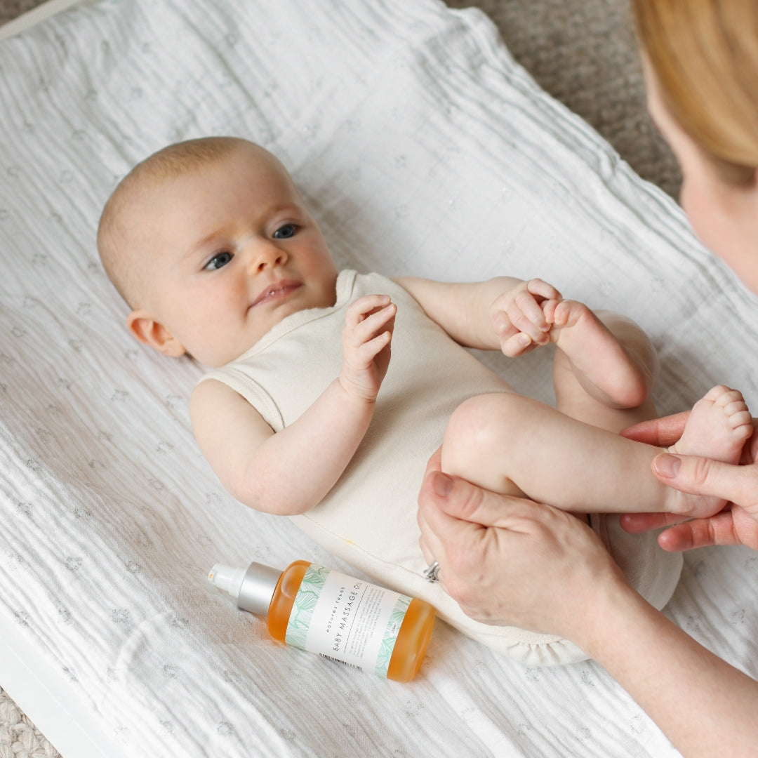 Mum massaging baby's legs with Natures Touch Baby Massage Oil
